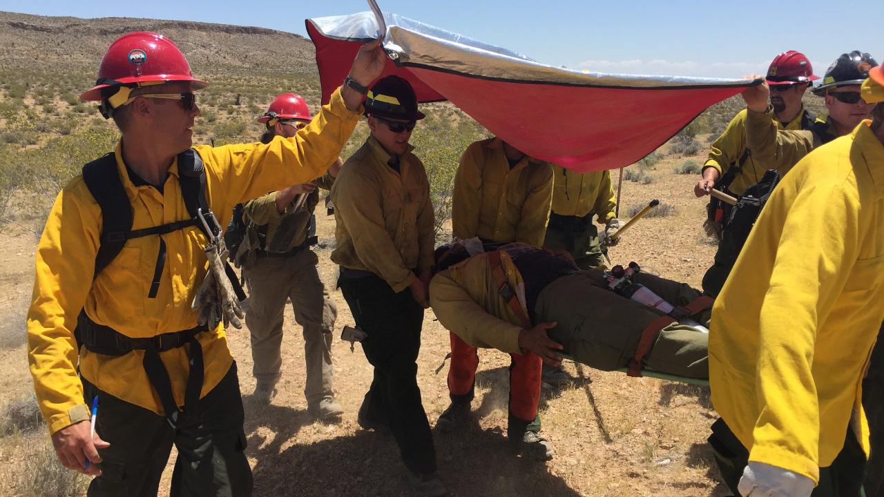 Outdoor works holding a tarp for shade
