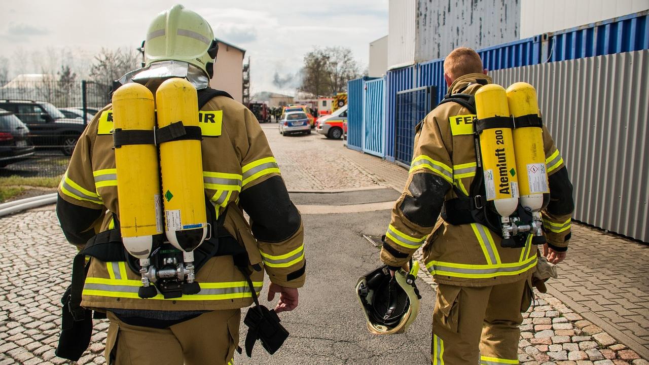 Two firefighters outside in full turnout gear
