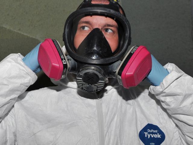 Employee wearing full face respirator
