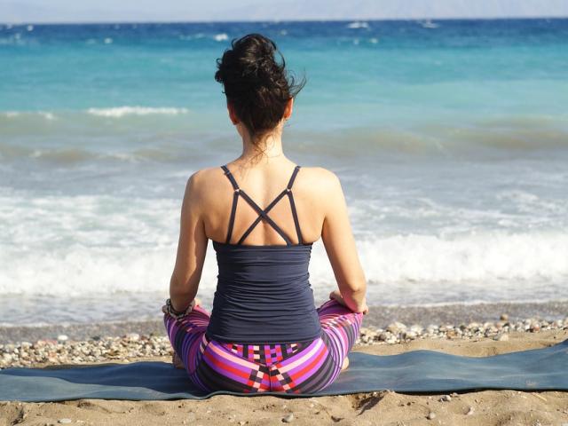 Woman meditating on the beach