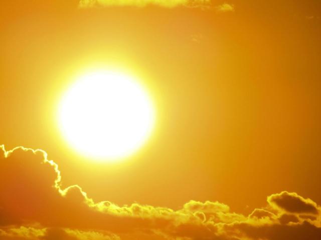 Hot sun above layer of clouds
