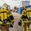 Two firefighters outside in full turnout gear