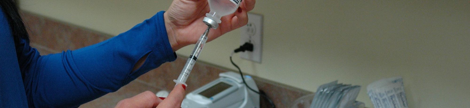 Nurse prepares vaccine syringe 