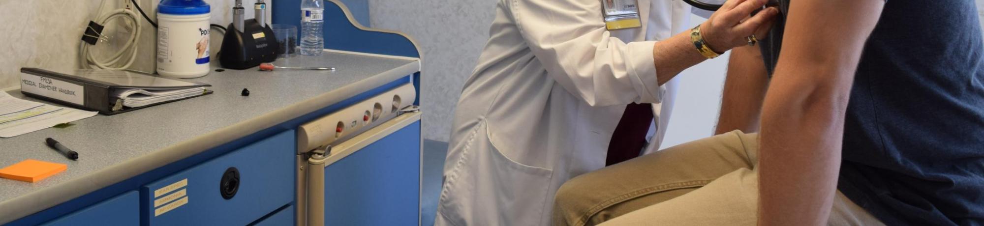 Doctor checking patient's heart rate with a stethoscope