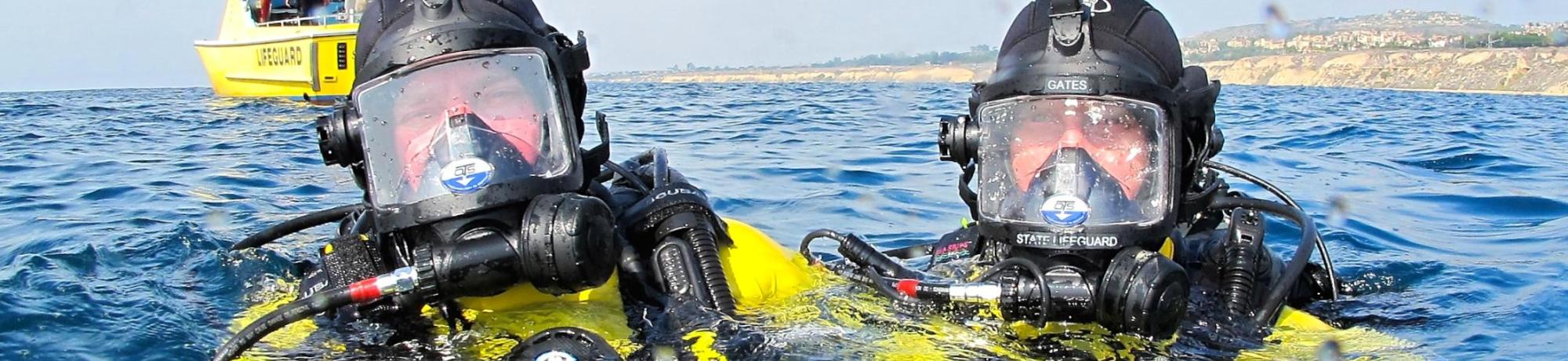 Two Divers in SCUBA gear with heads above water